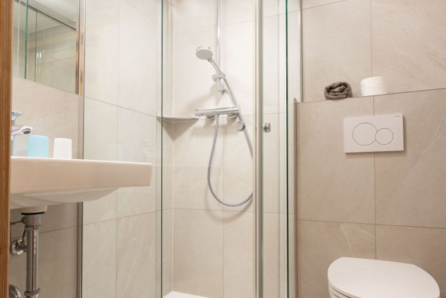 Ger&auml;umiges Badezimmer mit Dusche und WC
