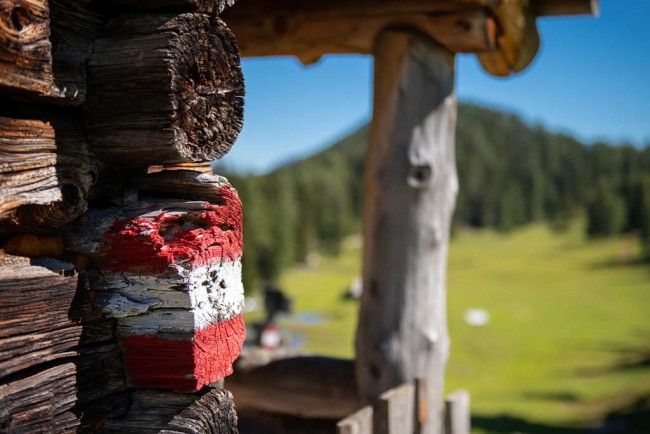 Wanderweg-Markierung auf Almhütte